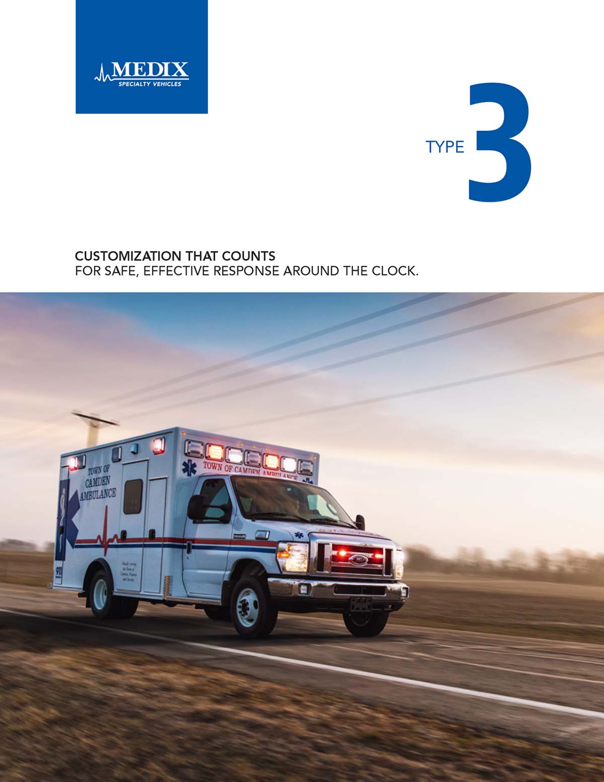 A Medix Type 3 Ambulance on a sunny day drives on a country road with fields and power lines in the background