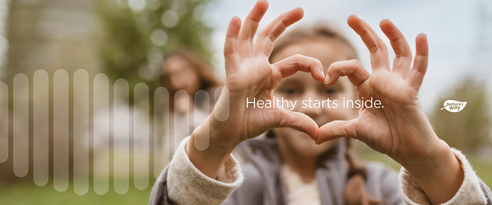 a young girl making a heart shape with her fingers