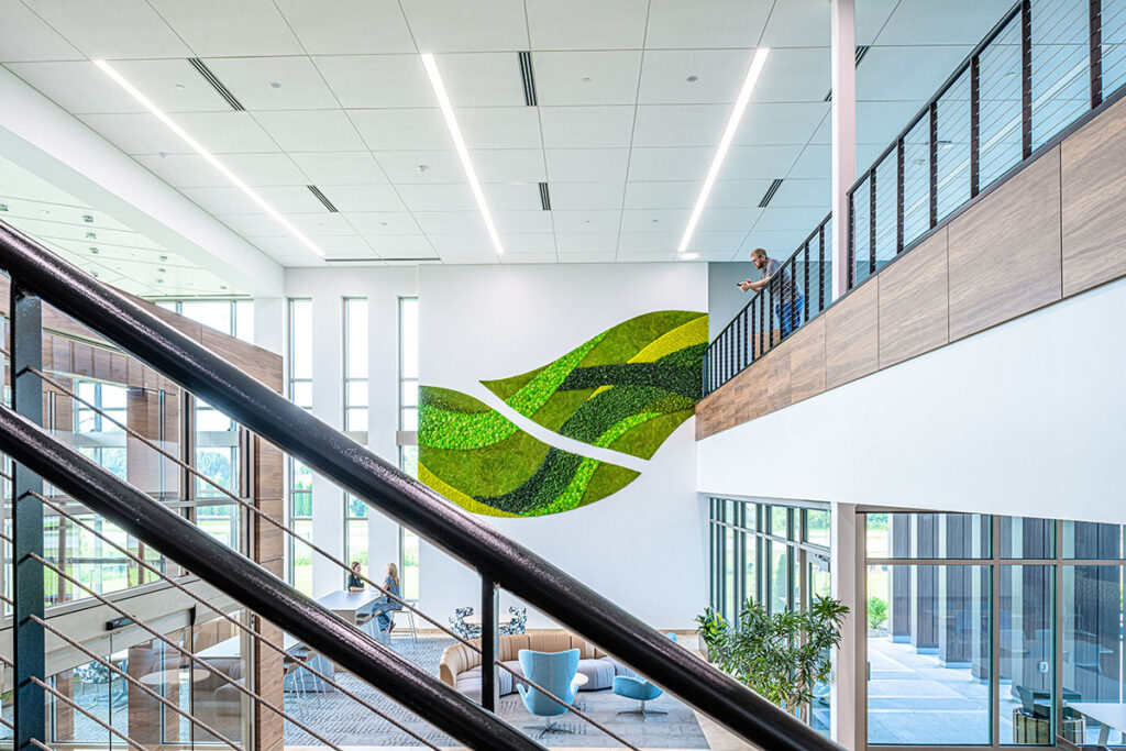 interior photo of the Green Bay Nature's Way facility showing a large space with two levels, and a large living wall of greenery at the far end